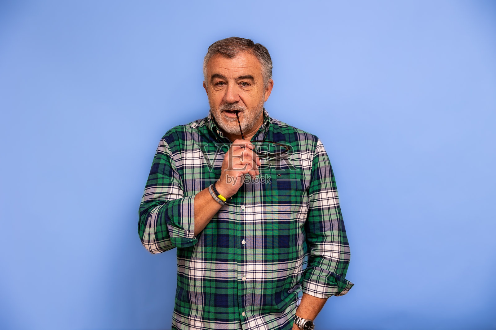 成熟的成年男子，手持眼镜沉思照片摄影图片