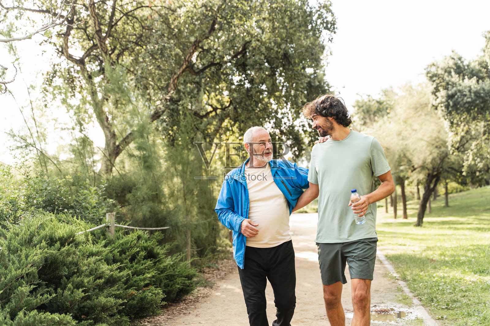 健康的老年父亲和儿子一起慢跑运动，为了积极的生活方式和家庭亲情而奔跑照片摄影图片