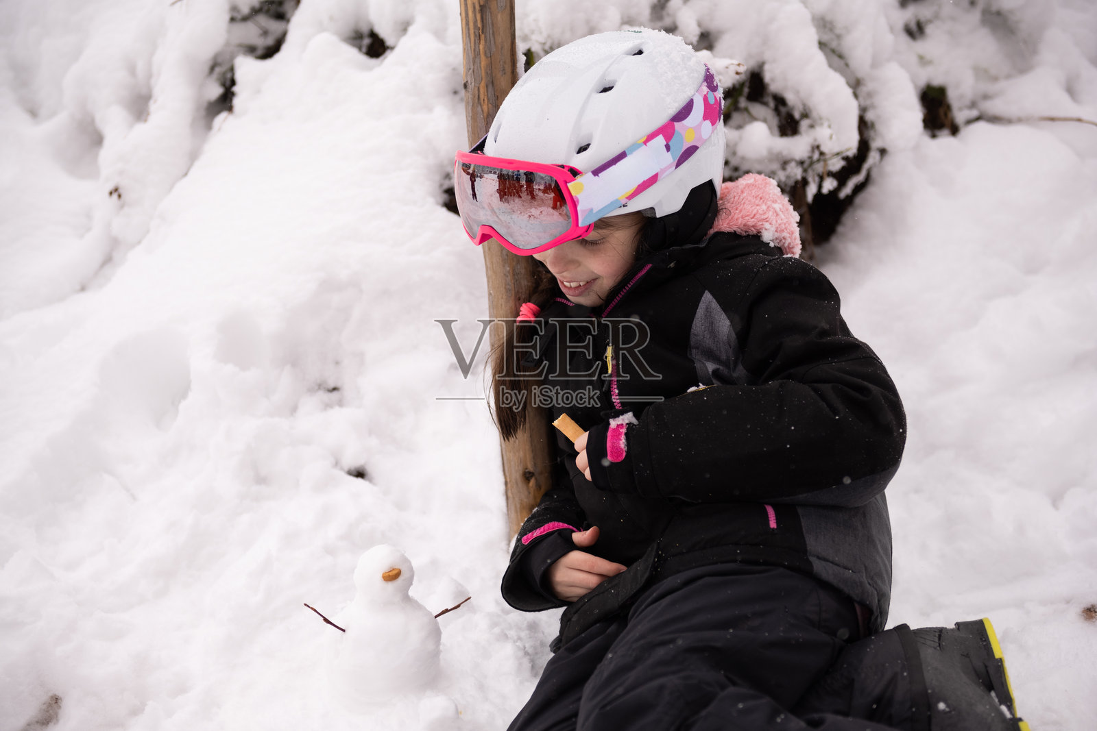 女孩在冬天玩一个小雪人照片摄影图片