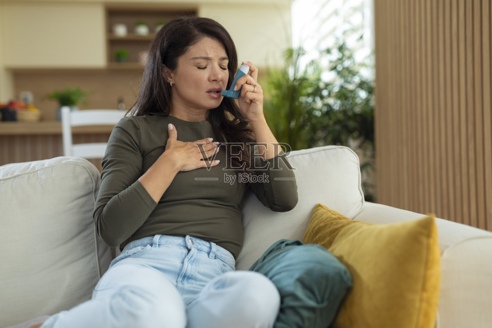 女子在家中哮喘发作，使用吸入器照片摄影图片