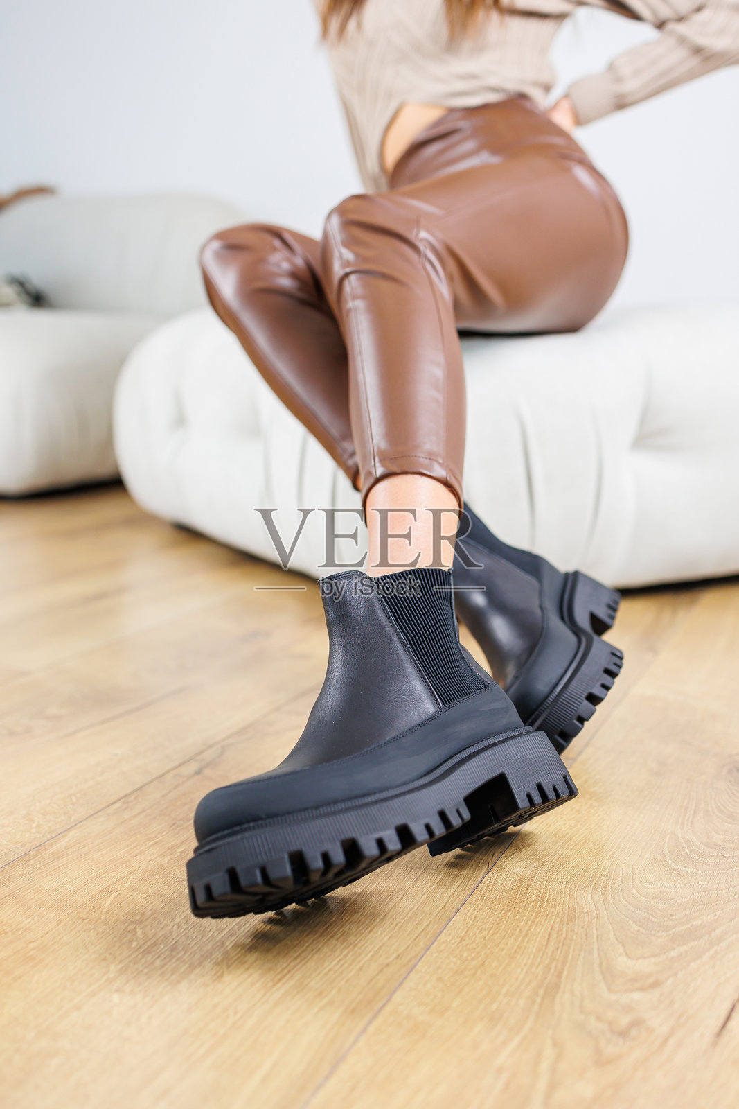 纤细女性的腿穿着黑色切尔西靴。女士春秋靴。女性的腿穿着棕色皮裤。照片摄影图片