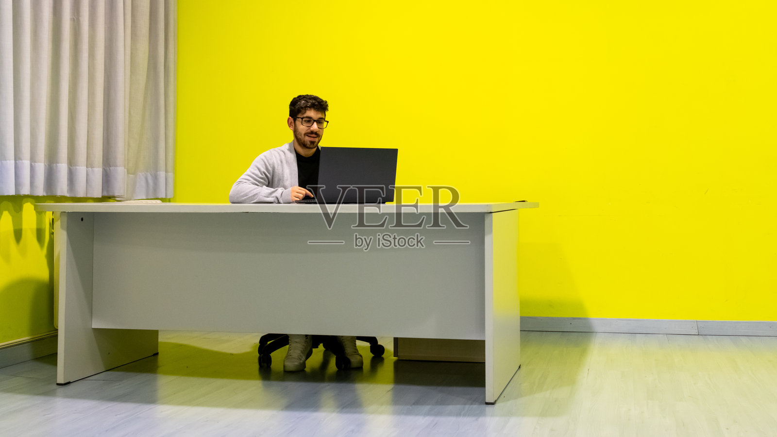 年轻人在现代办公室里用笔记本电脑工作照片摄影图片