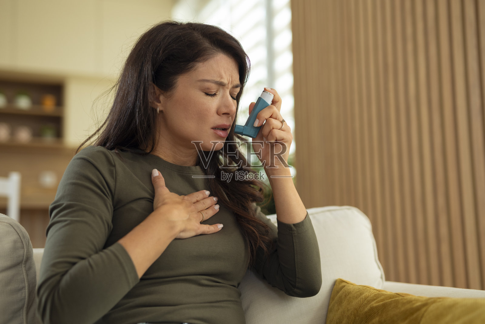 一名女性在家中使用吸入器应对哮喘发作照片摄影图片