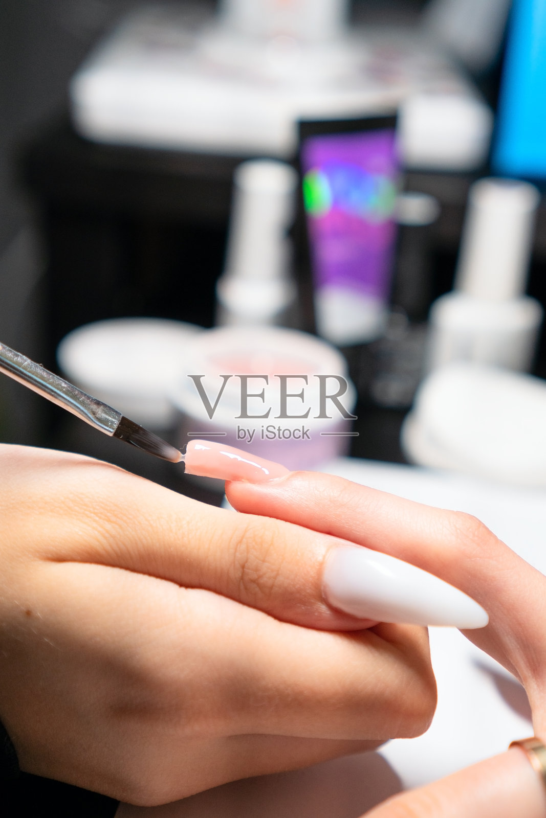 美甲师正在为延长甲完美涂抹凝胶照片摄影图片