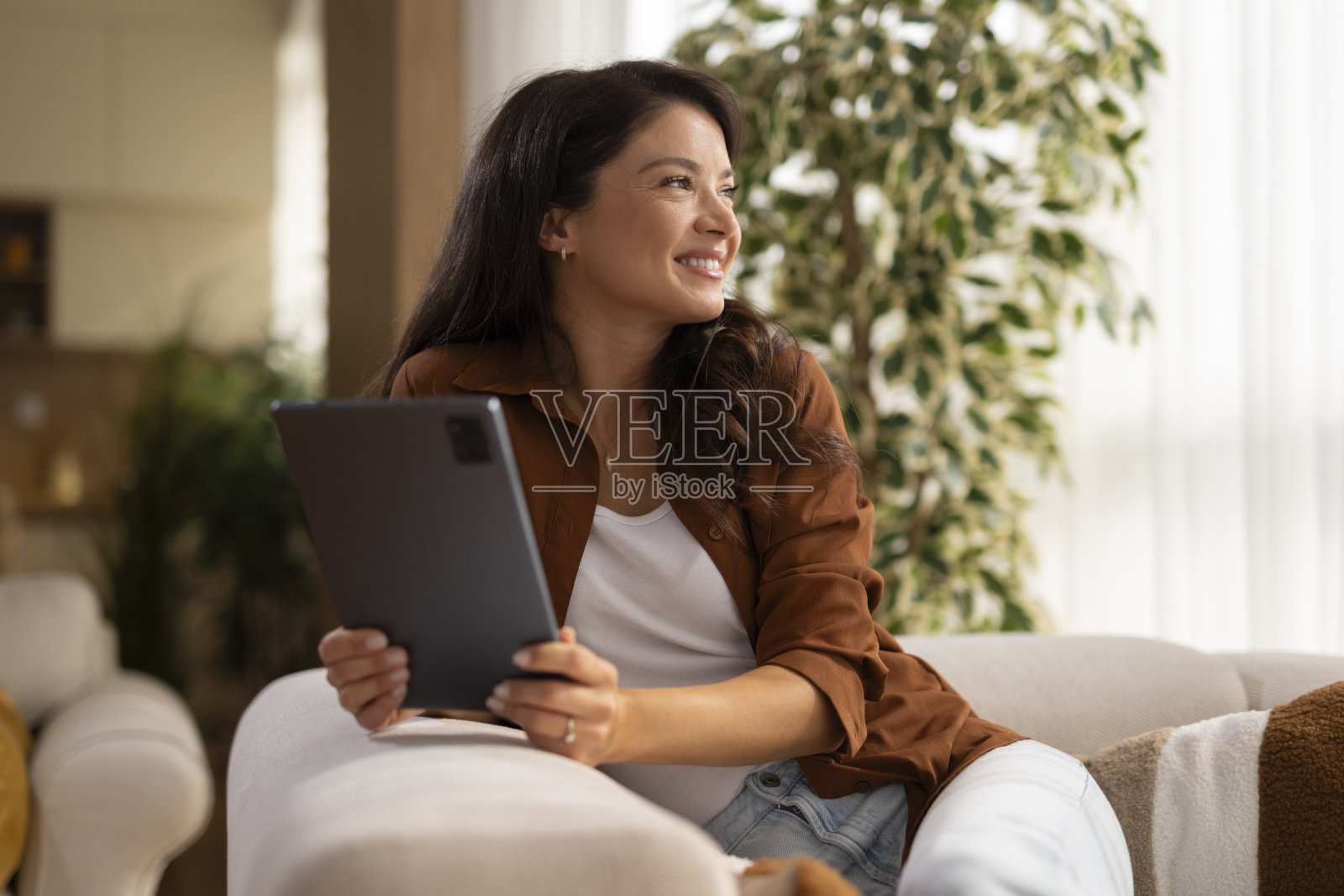年轻女子在家中放松地使用平板电脑照片摄影图片