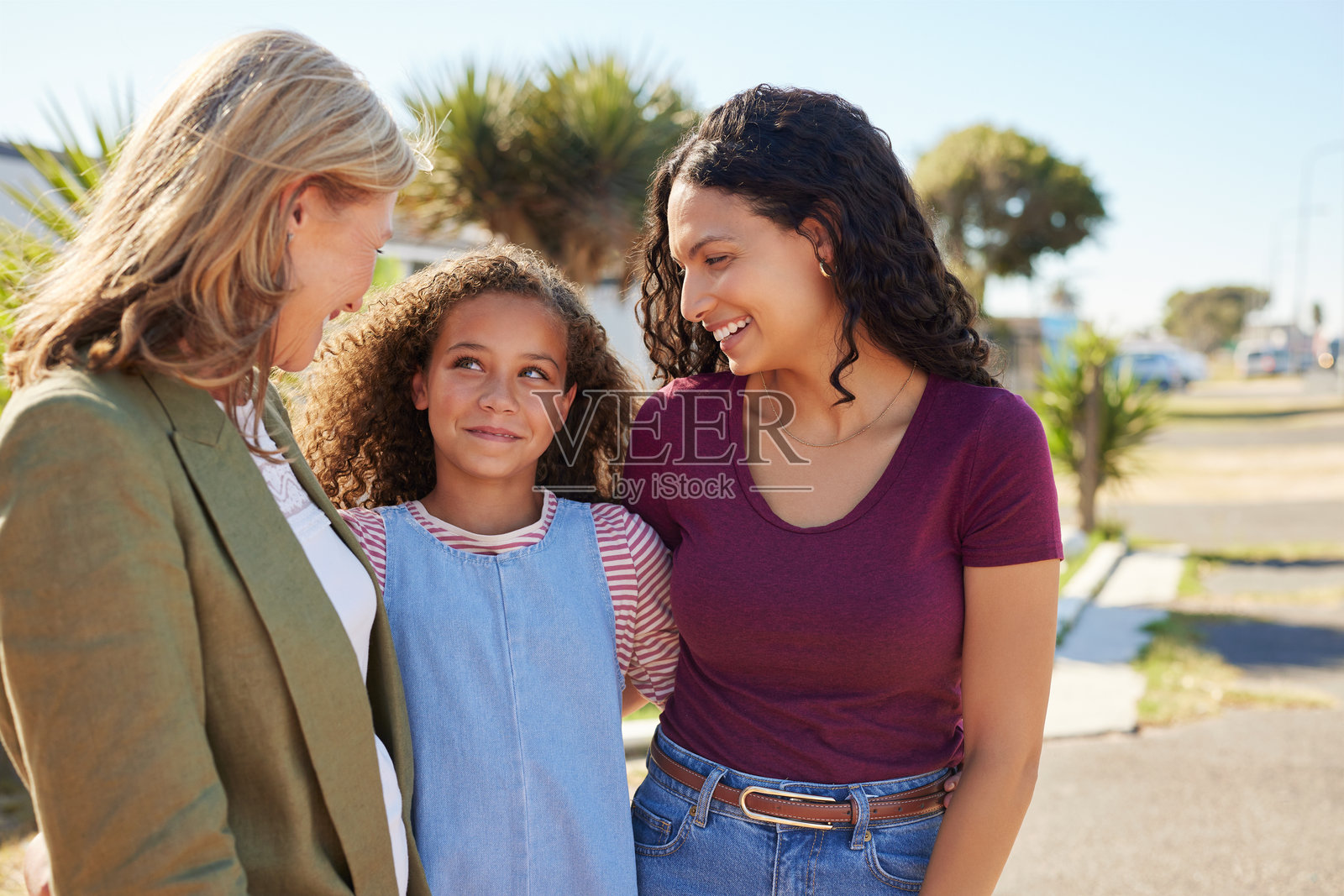 不同族裔的可爱小女孩与母亲和祖母在街上照片摄影图片