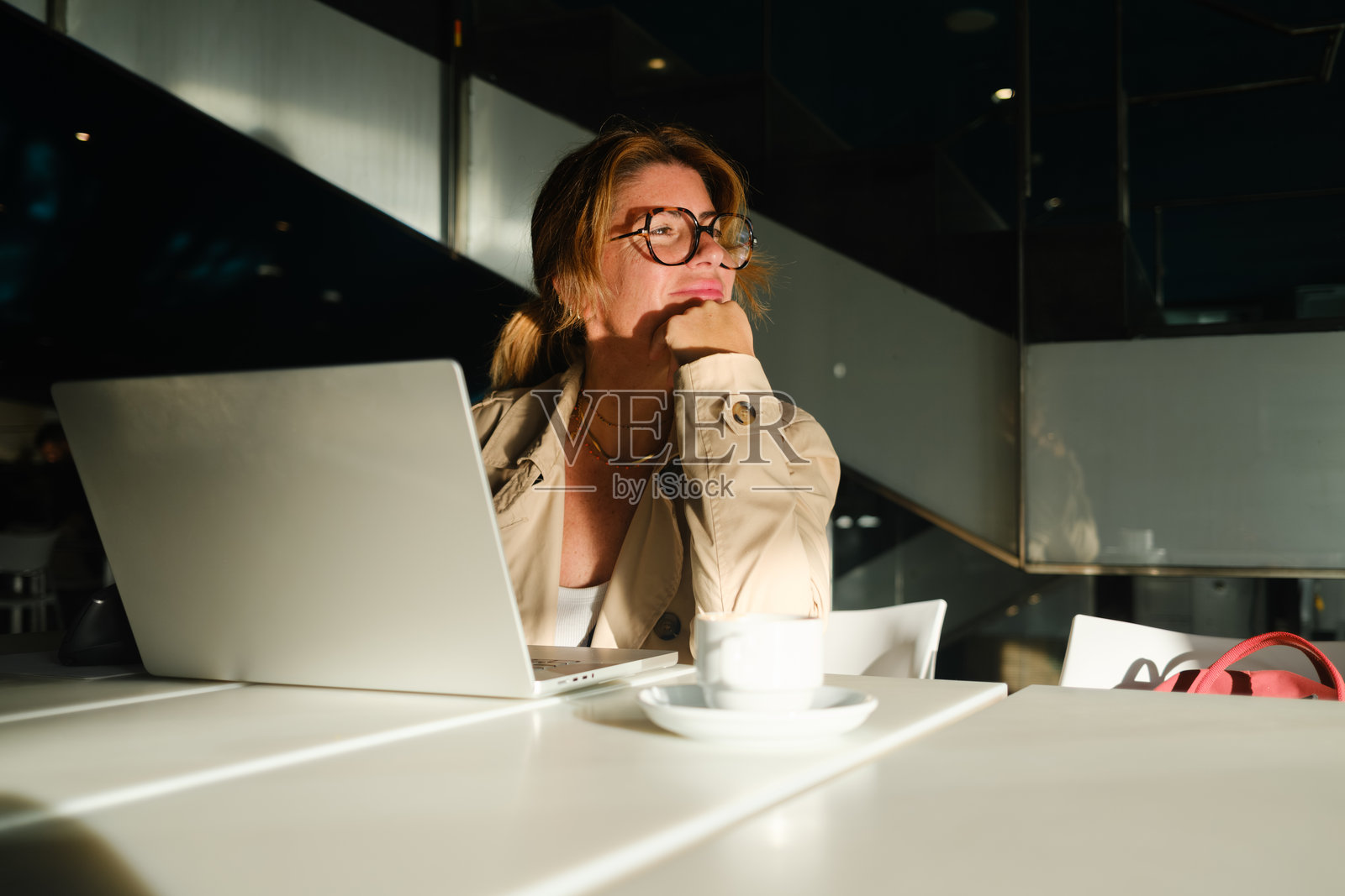 专业的女性在办公室咖啡馆用笔记本电脑思考，是头脑风暴和专注的概念。照片摄影图片