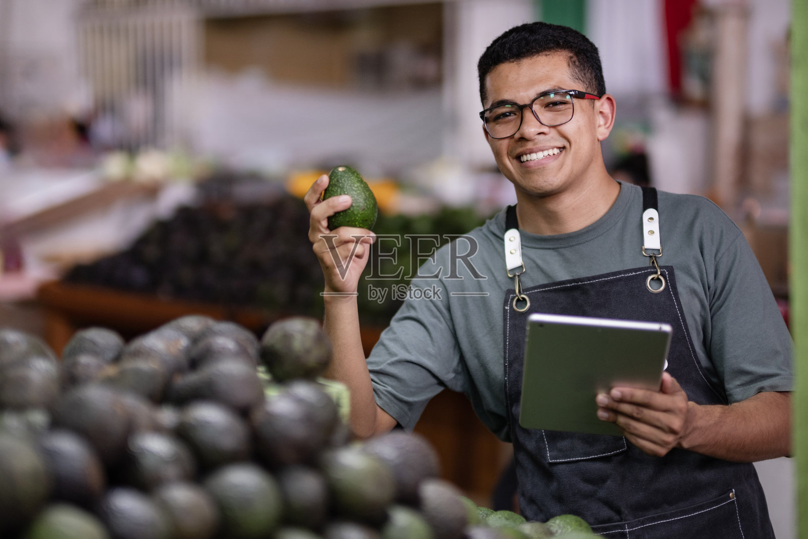 鳄梨销售商管理他的生意并检查产品质量照片摄影图片
