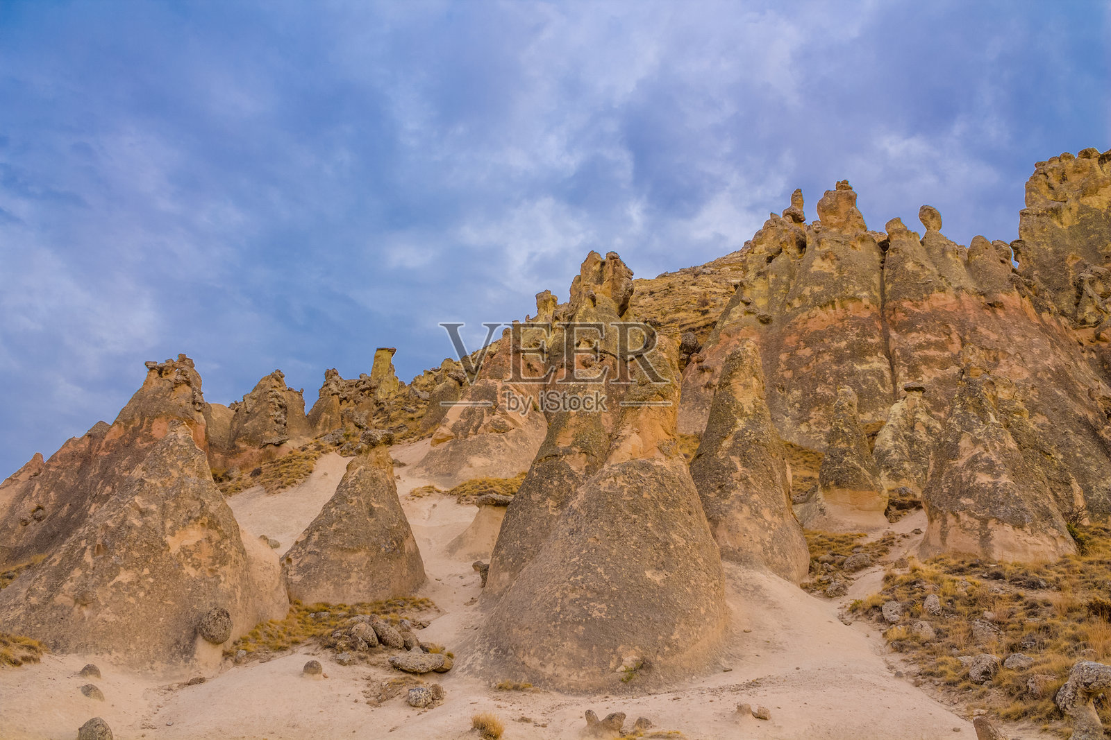 土耳其卡帕多奇亚的岩石构造，在晴朗的日光下，展现出高耸的砂岩烟囱、纹理分明的悬崖以及自然侵蚀形成的各种形状。照片摄影图片