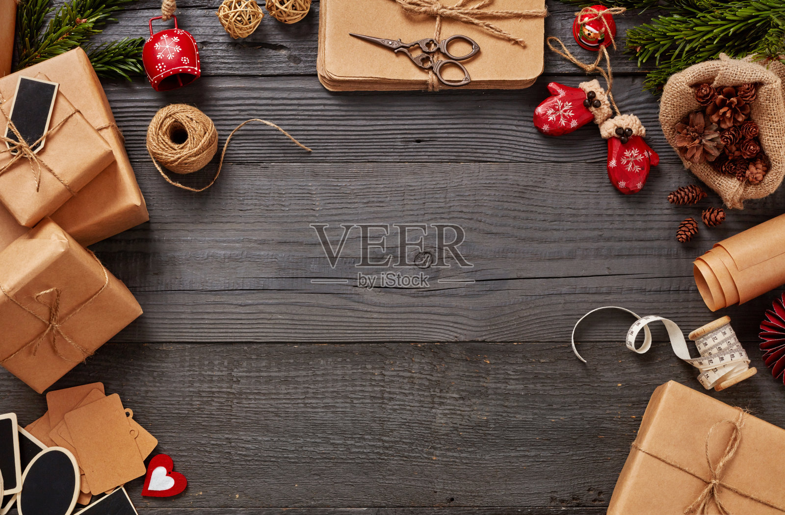 自制的包装圣诞礼物摆放在木桌上，旁边是节日装饰品照片摄影图片
