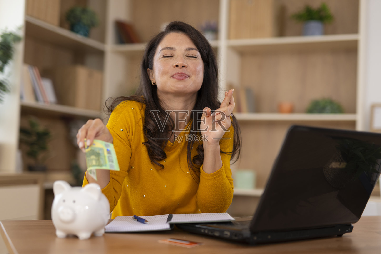 女士将欧元存入存钱罐，祈求好运照片摄影图片