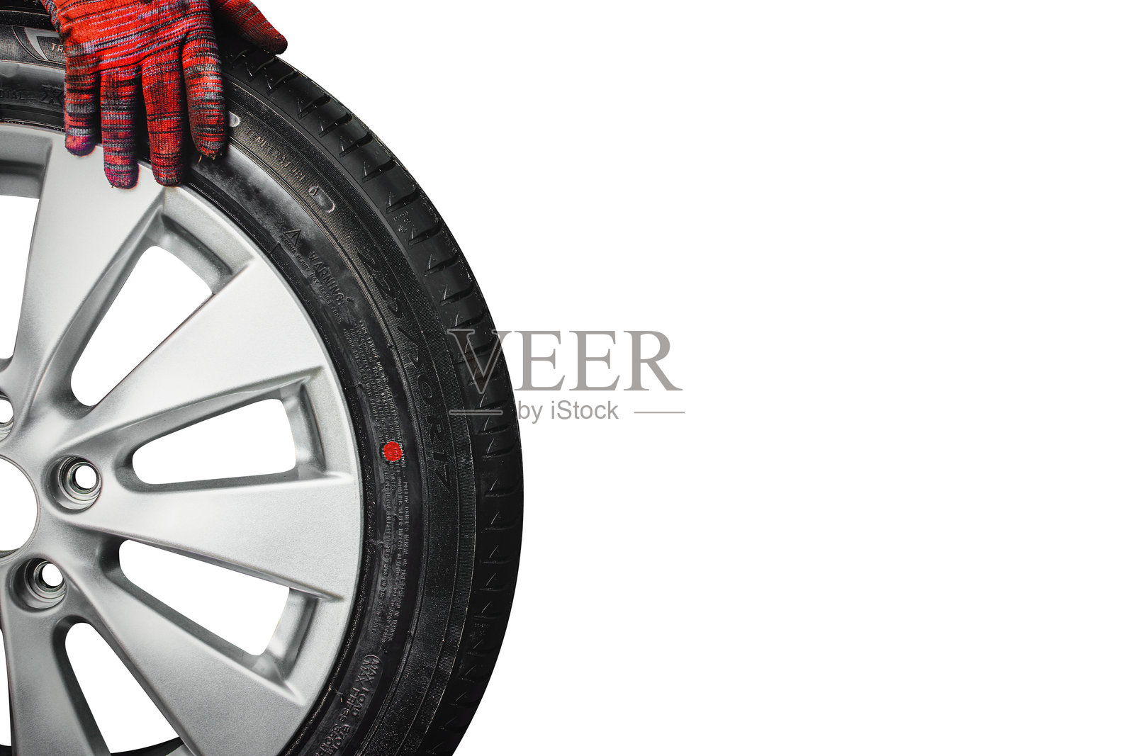 戴着手套的机械师手持汽车轮毂和轮胎，准备安装。专业的轮胎服务和汽车维修。照片摄影图片