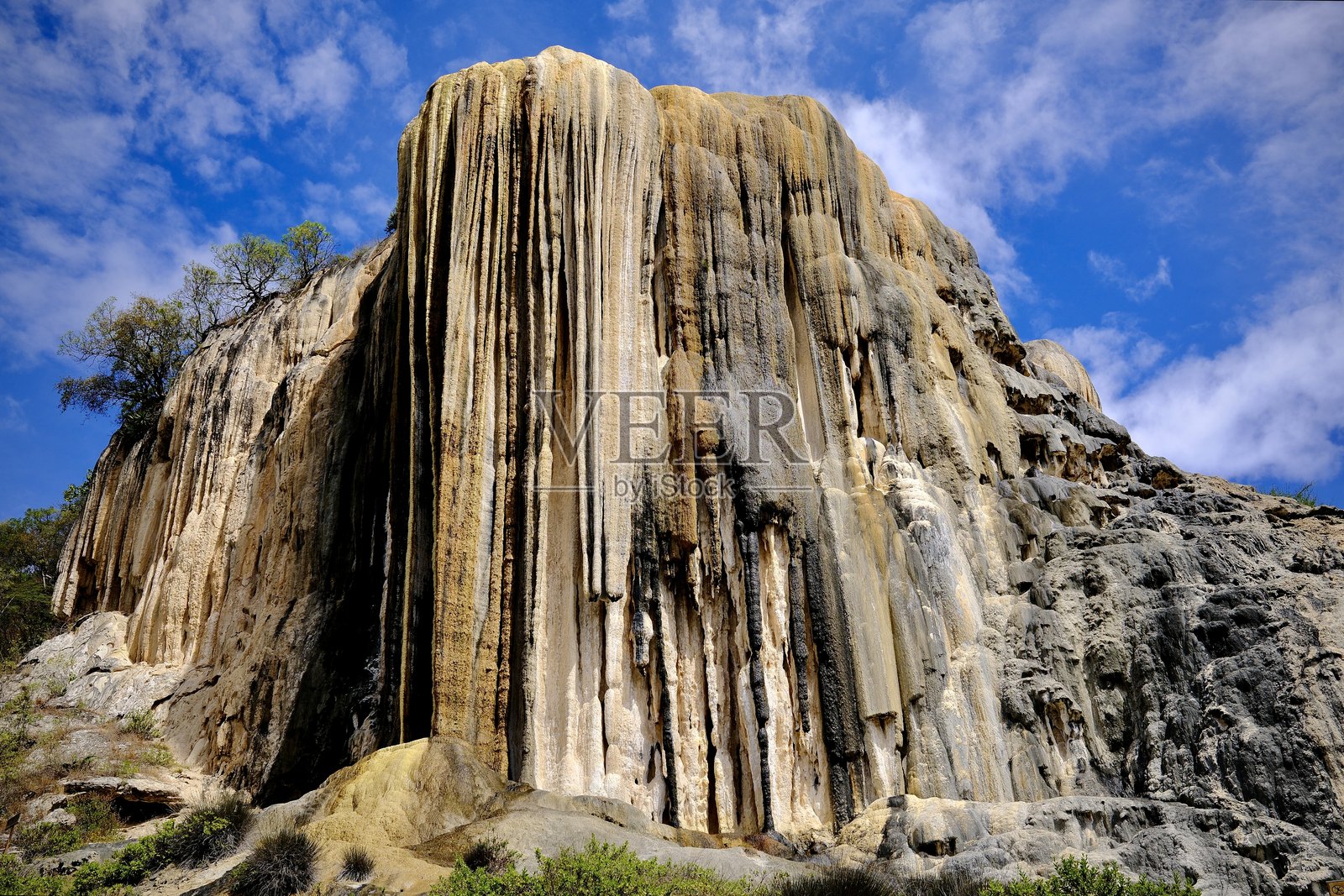 petrified waterfall cliff face against blue sky (Hierve el Agua, Mexico)照片摄影图片