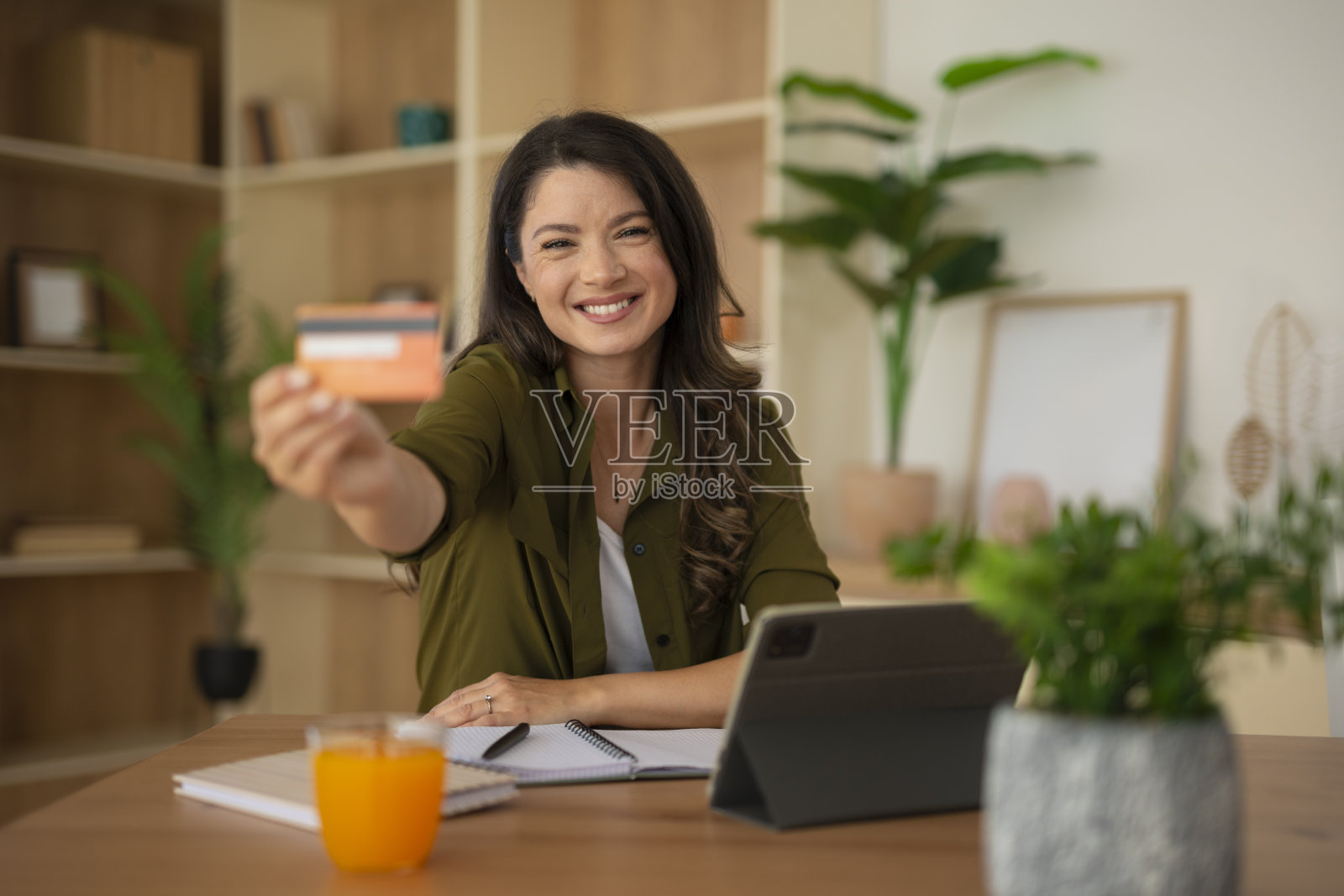 微笑的女性持信用卡进行网上购物照片摄影图片