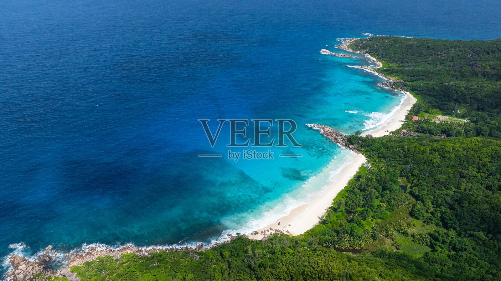 海岸线，郁郁葱葱的绿色植被，清澈的海水。塞舌尔，拉迪格岛。照片摄影图片