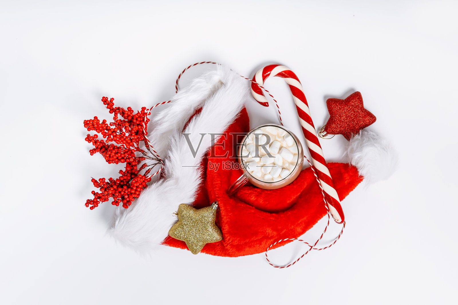 舒适的冬季场景，包含针织手套、红浆果、圣诞装饰品、拐杖糖和上面放有棉花糖的热饮杯。非常适合作为圣诞背景。照片摄影图片