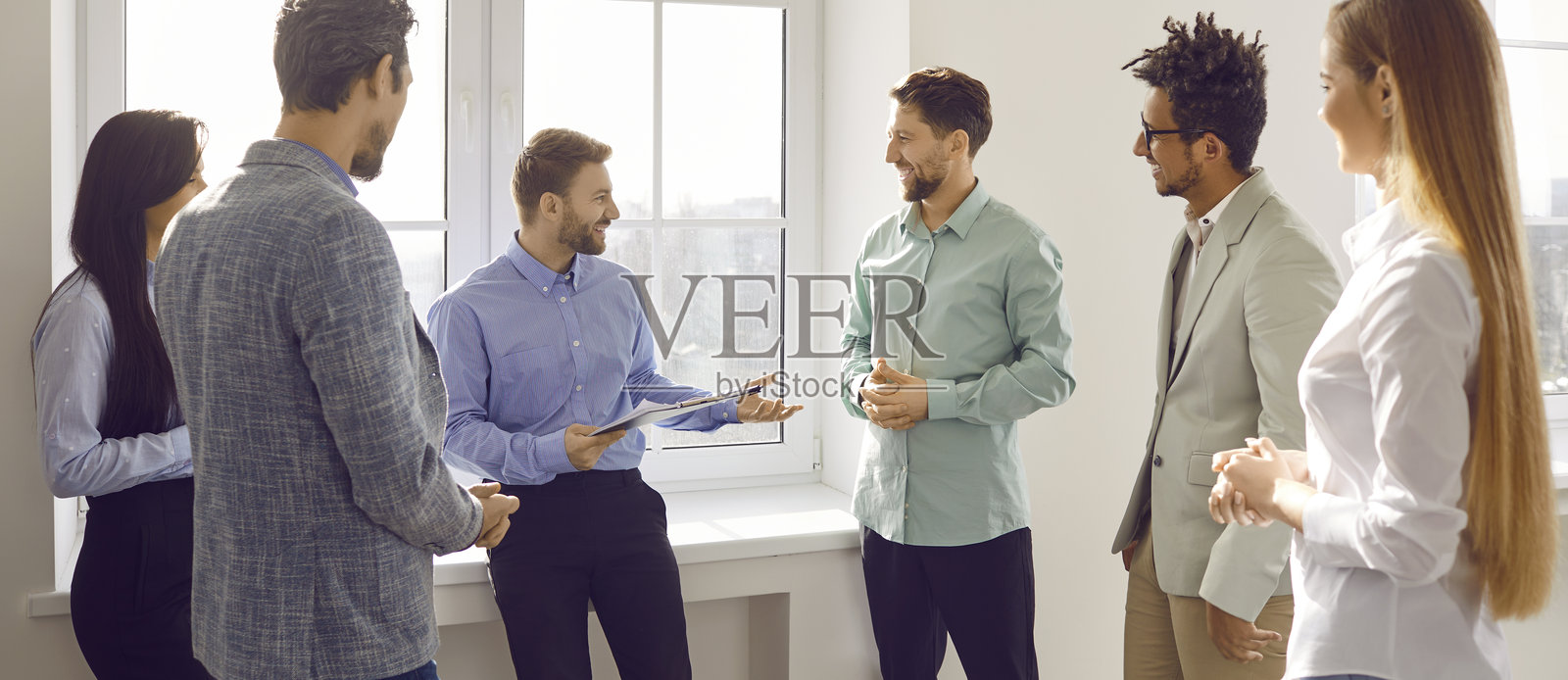 一群商务人士在会议结束后交谈。公司员工在办公室里聊天。照片摄影图片