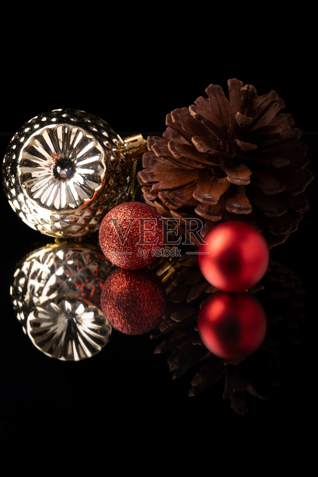 圣诞装饰品，精美的圣诞装饰品放置在镜面上，黑色背景，选择性对焦。照片摄影图片