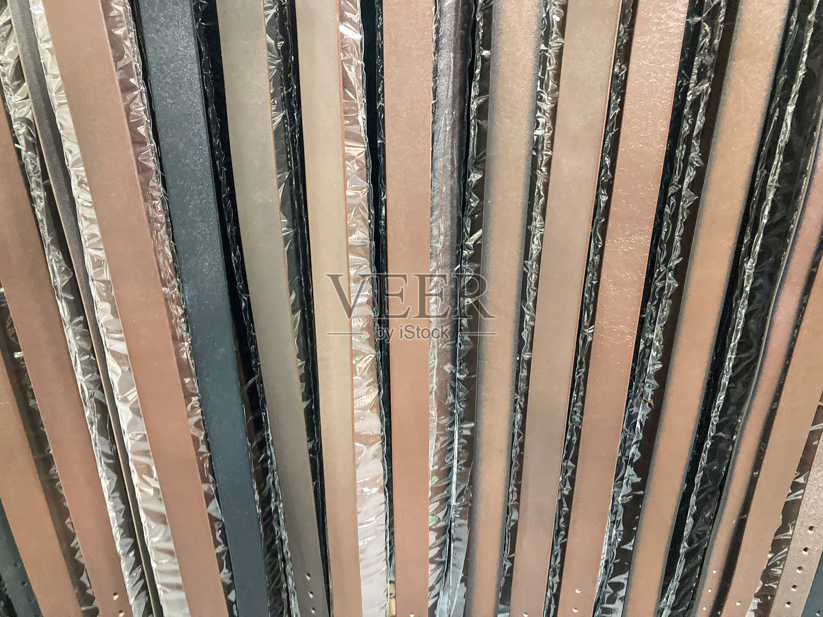 抽象图案中重叠的、红橙色的金属碎片集合，大小和方向各不相同。室内环境，有柔和的阴影，无文字或品牌标志。静物构图，聚焦于照片摄影图片