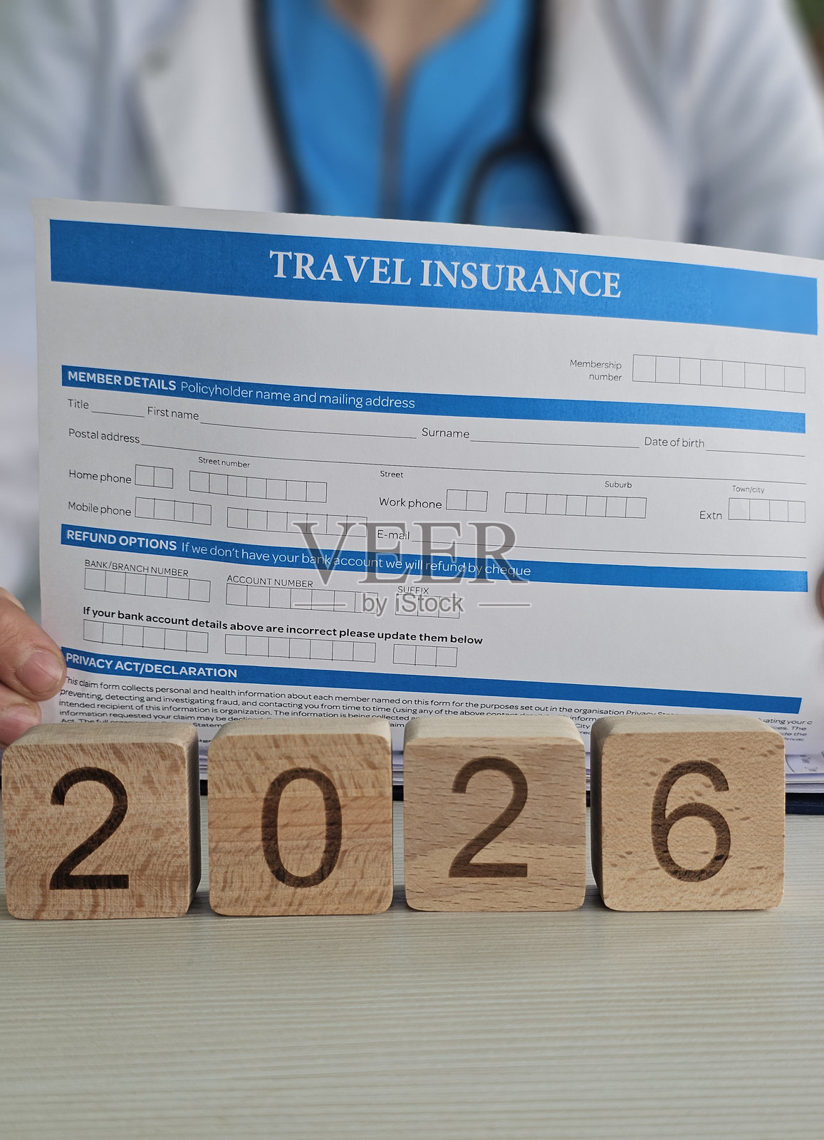 填写2026年旅行保险表格，用木块表示年份概念照片摄影图片