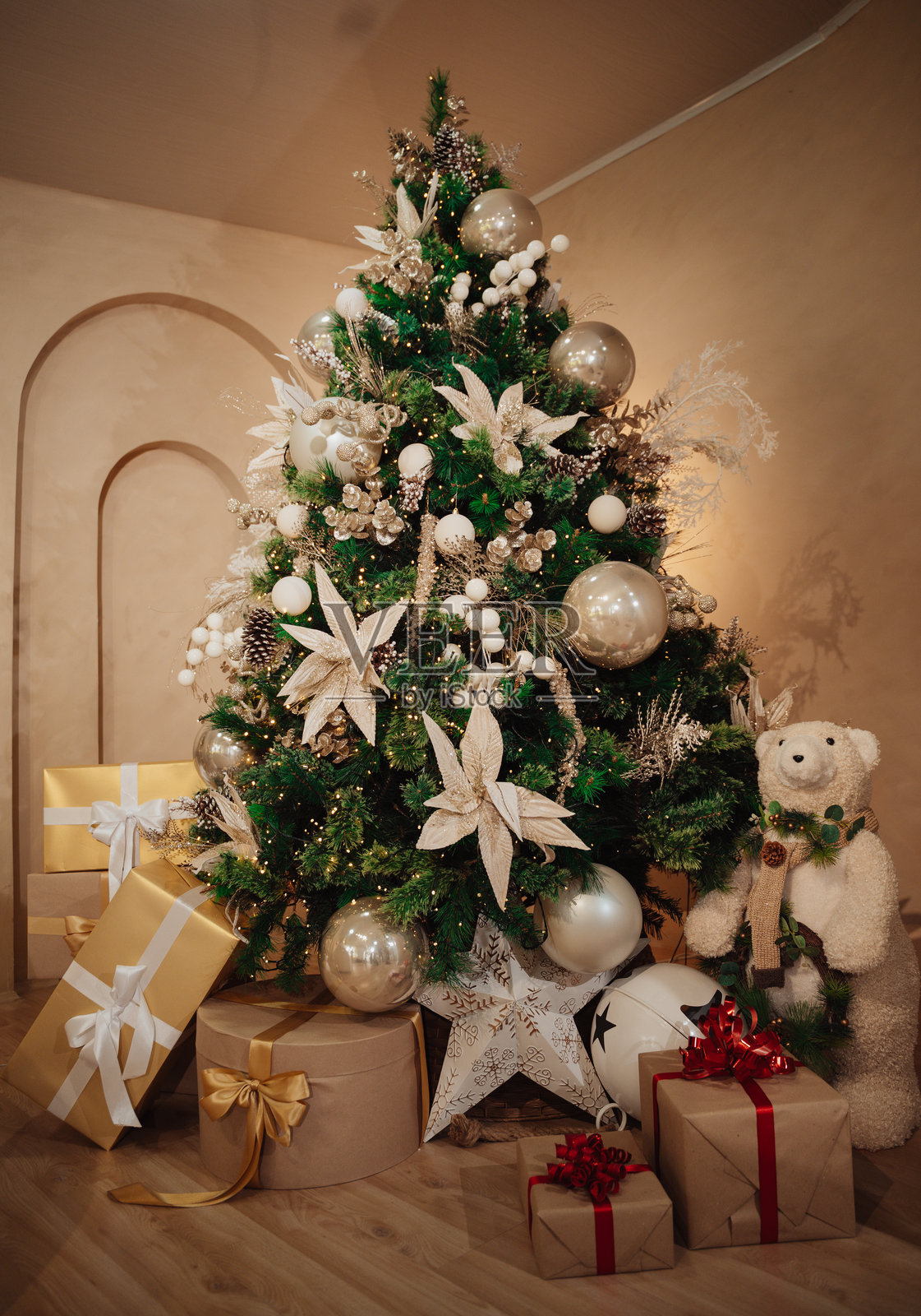 室内圣诞树，挂满装饰和灯饰，树下堆放着礼物照片摄影图片