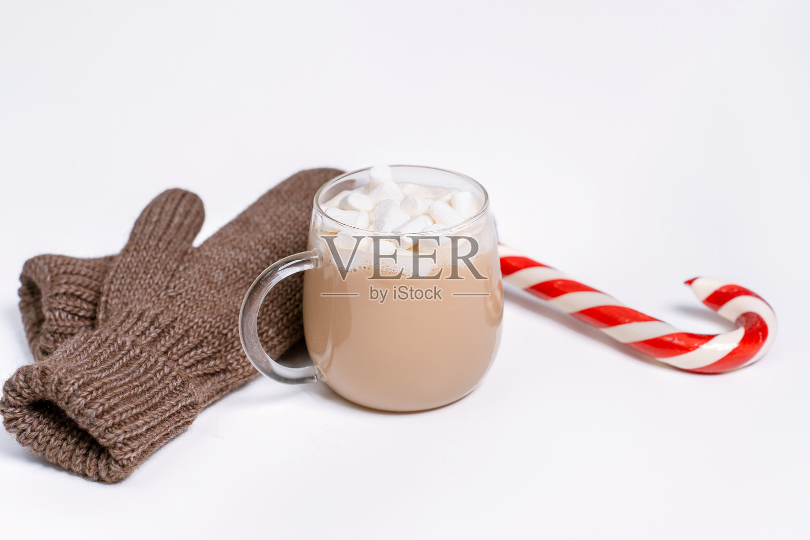 圣诞节场景平面图，有针织手套、拐杖糖和上面有棉花糖的热饮杯，背景为白色。非常适合作为圣诞背景照片摄影图片