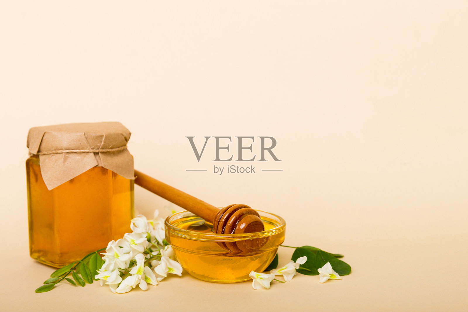 彩色桌子上的刺槐花金合欢蜂蜜瓶照片摄影图片