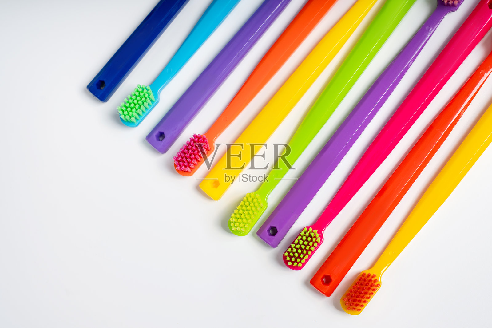 彩色牙刷整齐地排列在白色孤立的背景上照片摄影图片
