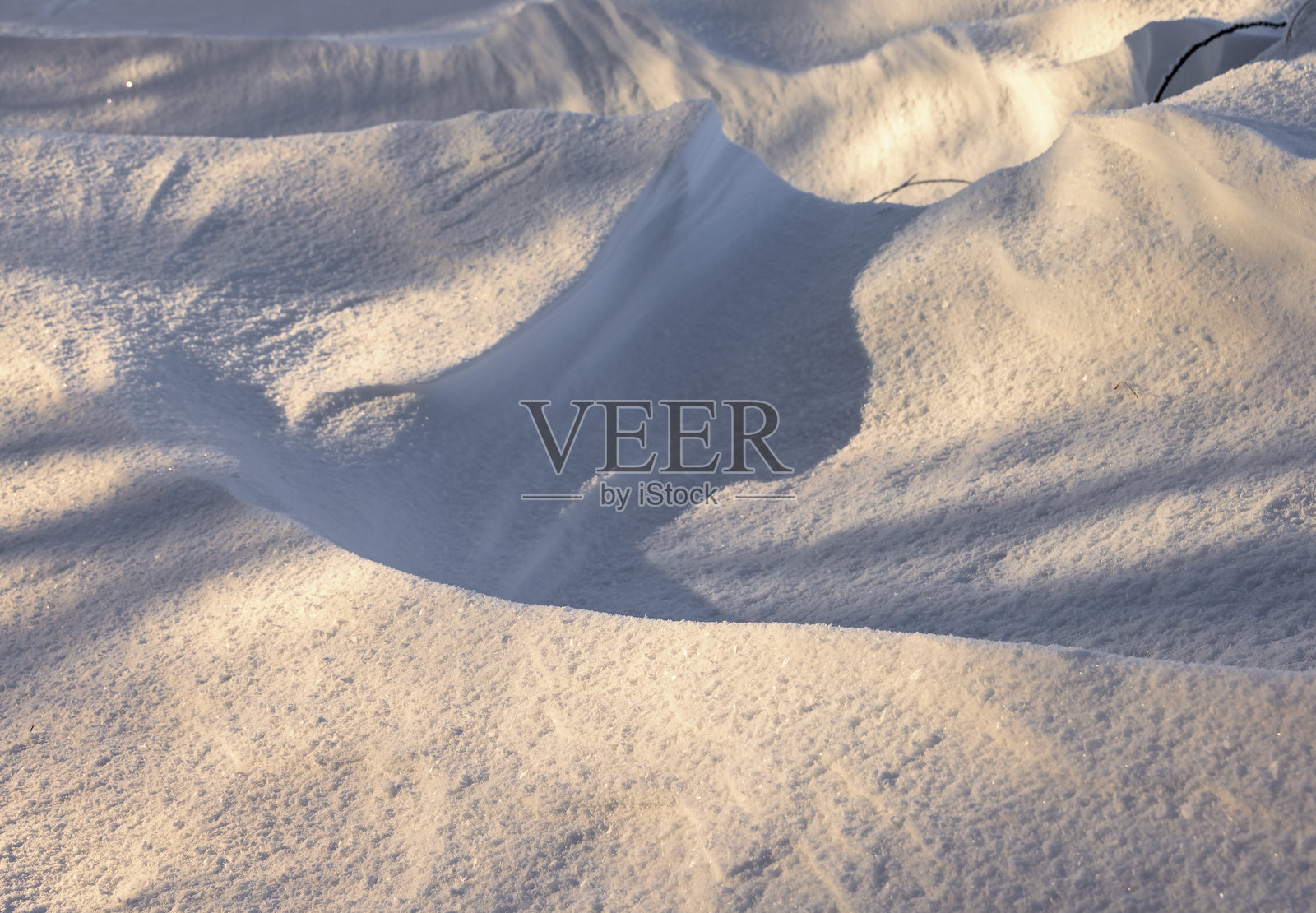 冬季雪堆上的抽象阴影图案照片摄影图片