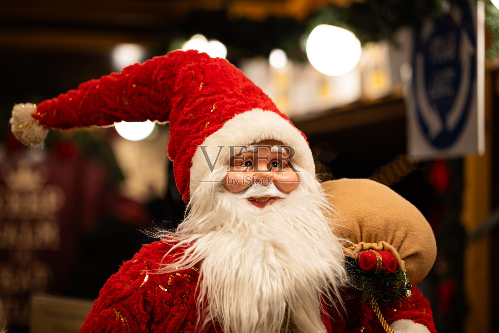 近景拍摄、人像模式、浅景深，无人。大型圣诞老人玩具玩偶装饰着圣诞集市摊位。照片摄影图片