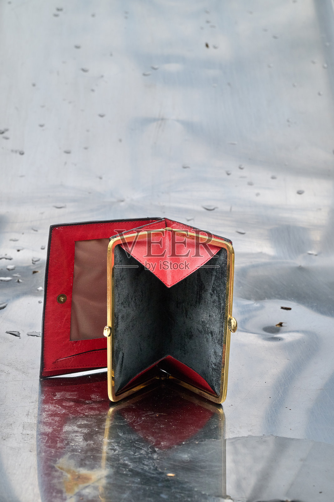 打开的钱包放在闪亮的金属背景上照片摄影图片