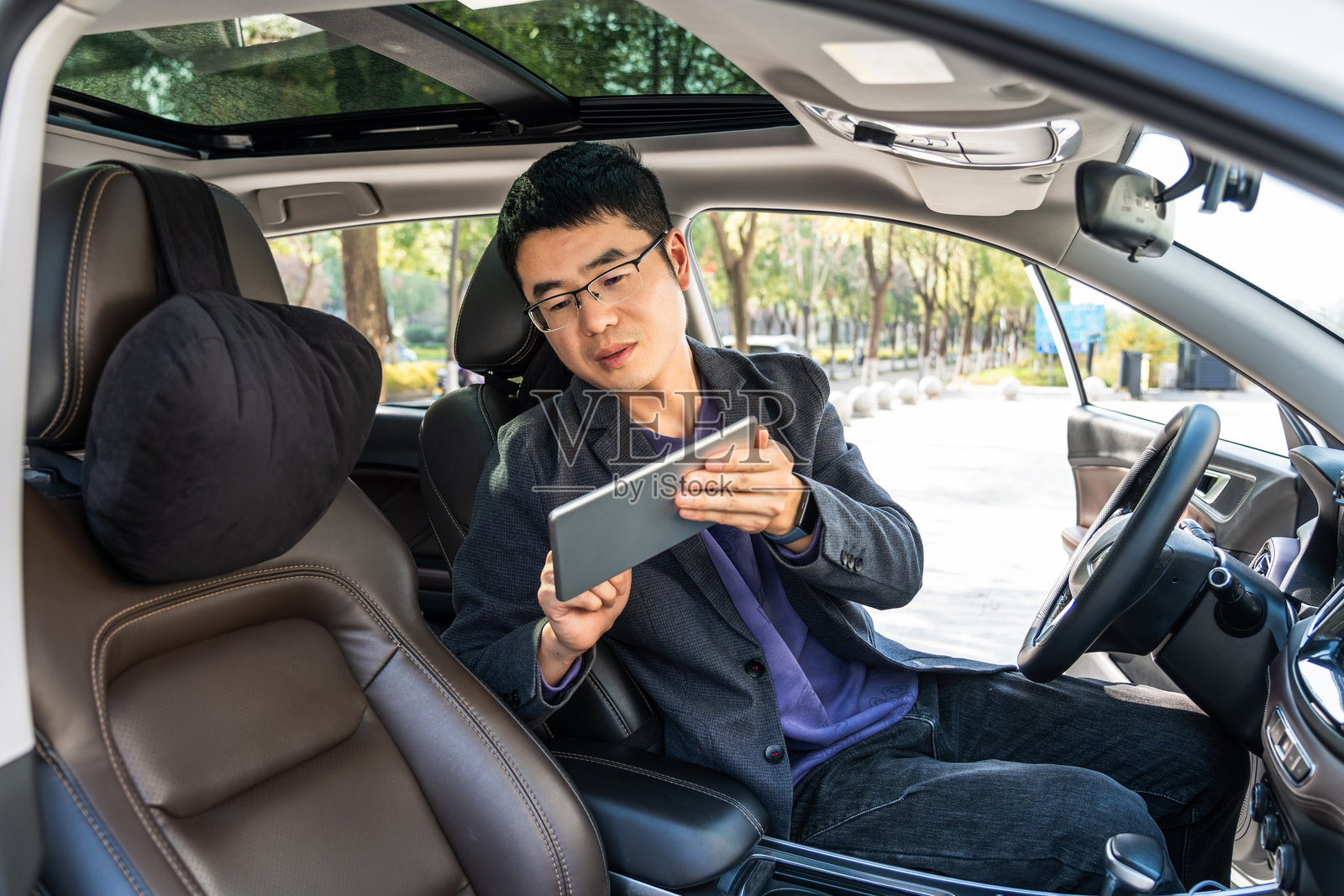 男人坐在车里使用平板电脑工作或休闲照片摄影图片