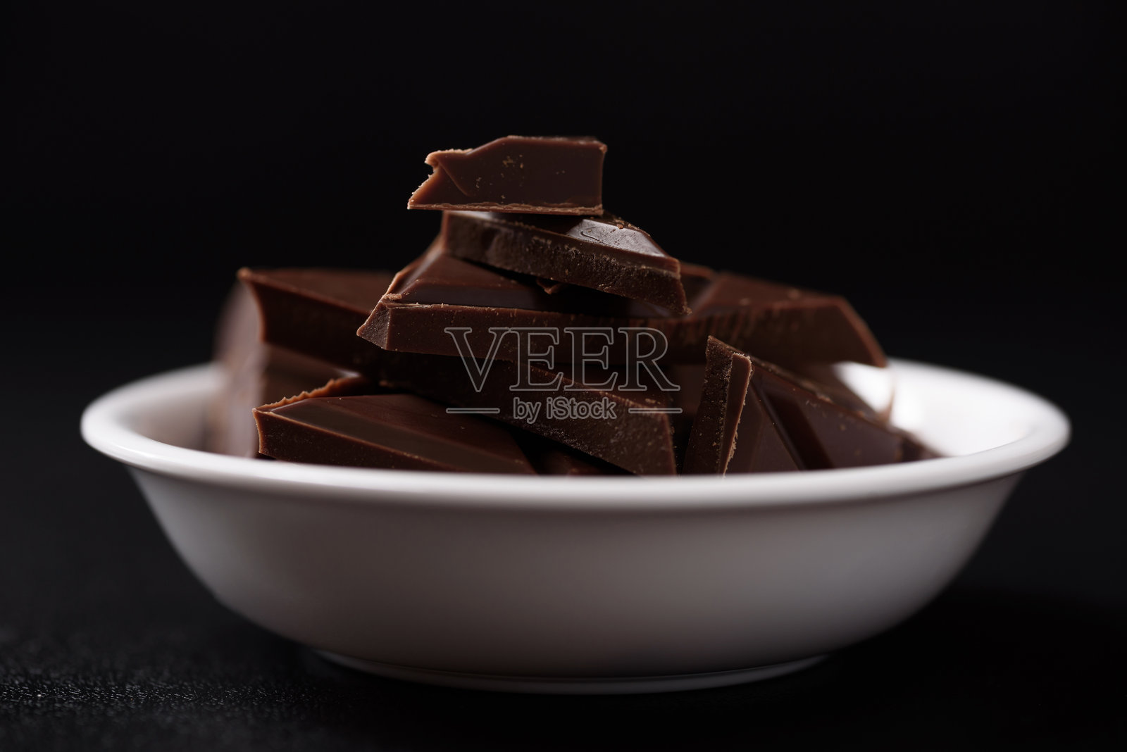 小块巧克力棒在黑色背景上排列照片摄影图片