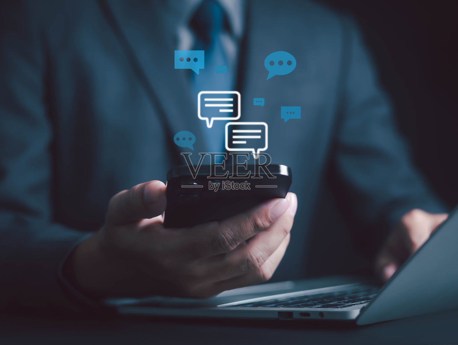 商务人士使用智能手机与数字聊天图标互动，象征着在线沟通、社交媒体、即时消息、移动应用、客户支持，适用于商务社交、营销和数字连接。照片摄影图片