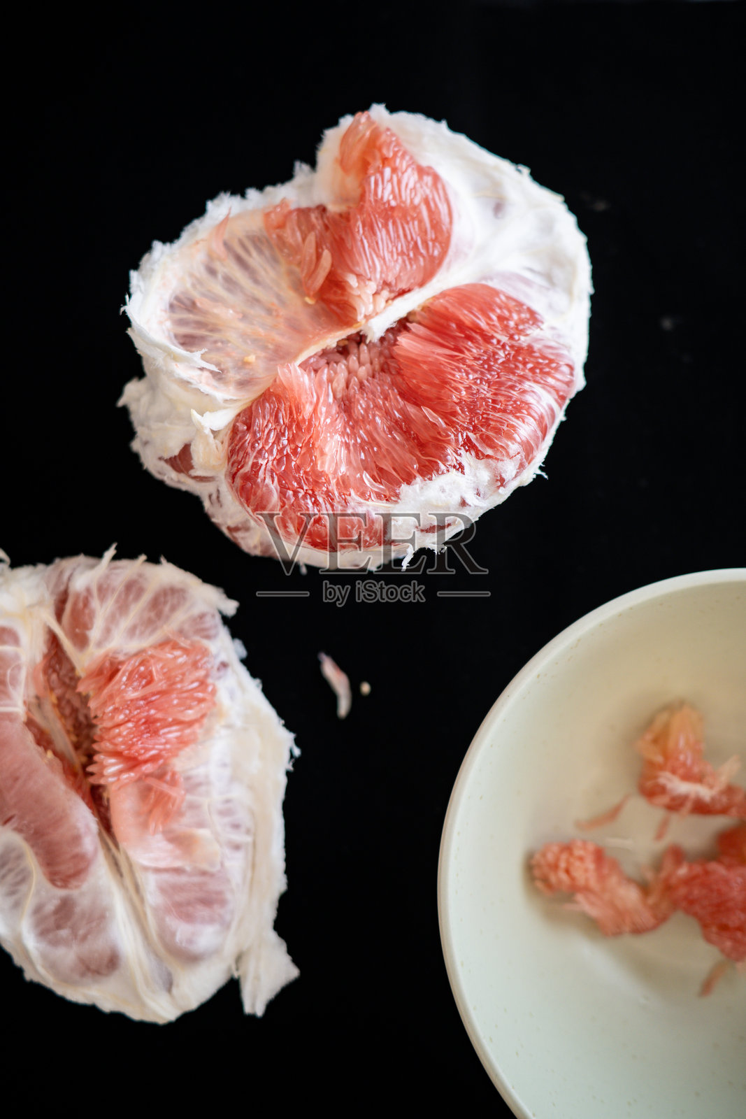 去皮的红心柚子和一碗果肉照片摄影图片