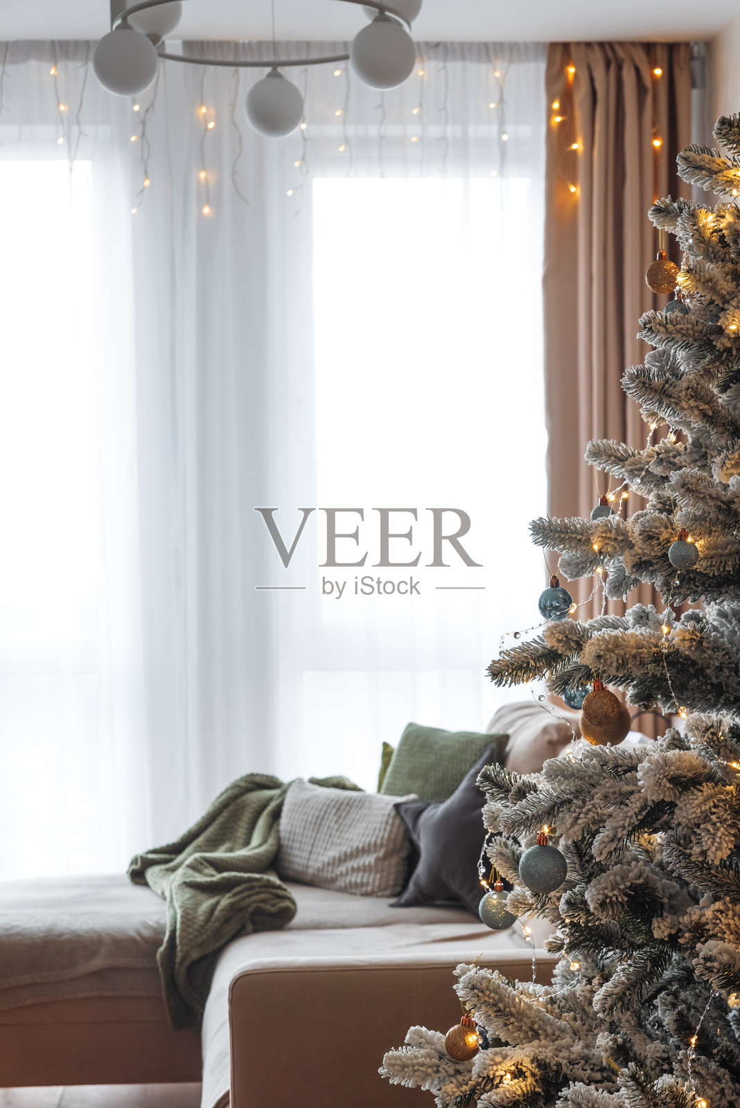 温馨的客厅，装饰着覆雪的圣诞树和舒适的摆设照片摄影图片