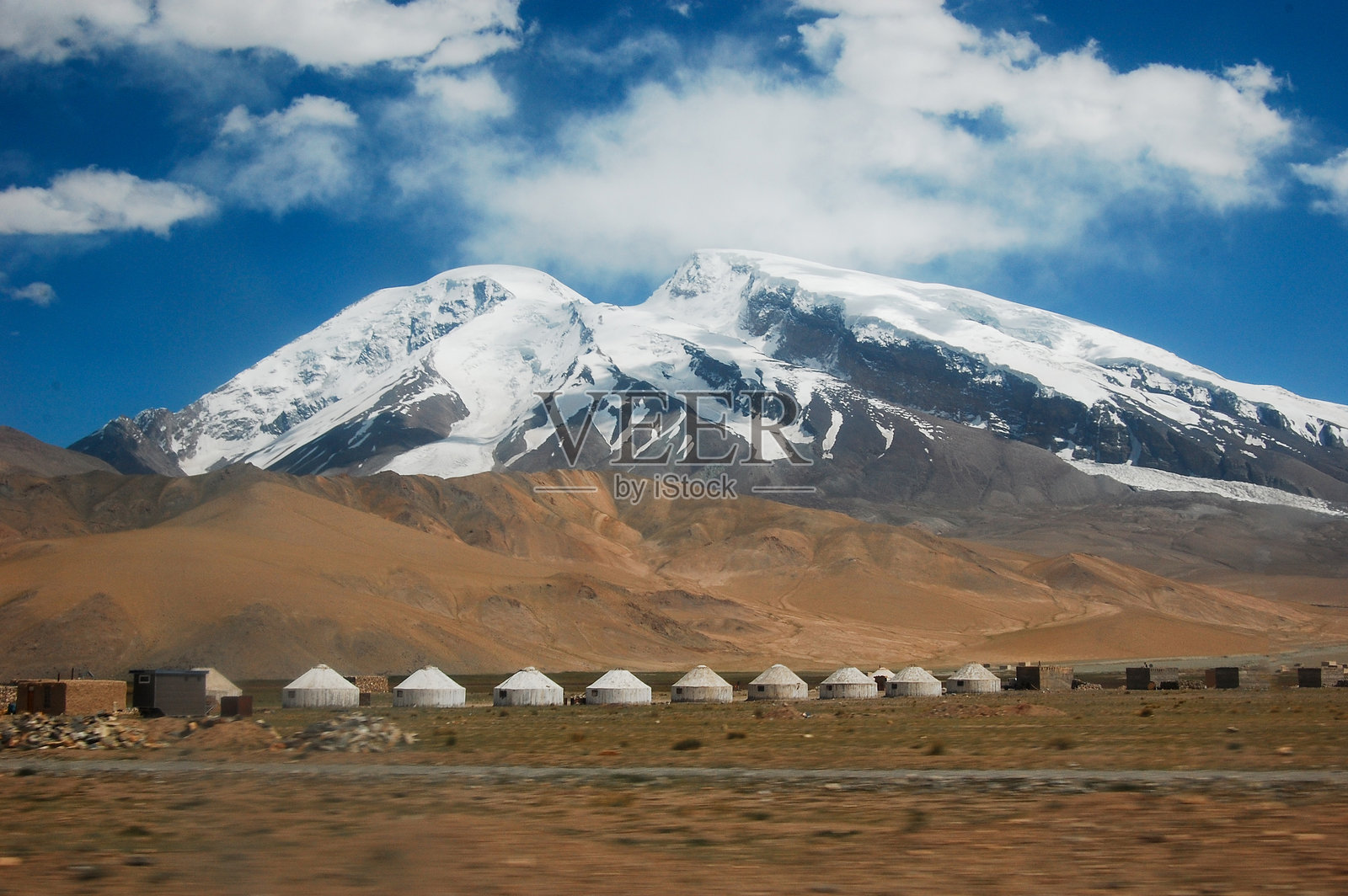 蓝天下，前景是传统的蒙古包，背景是雪山照片摄影图片