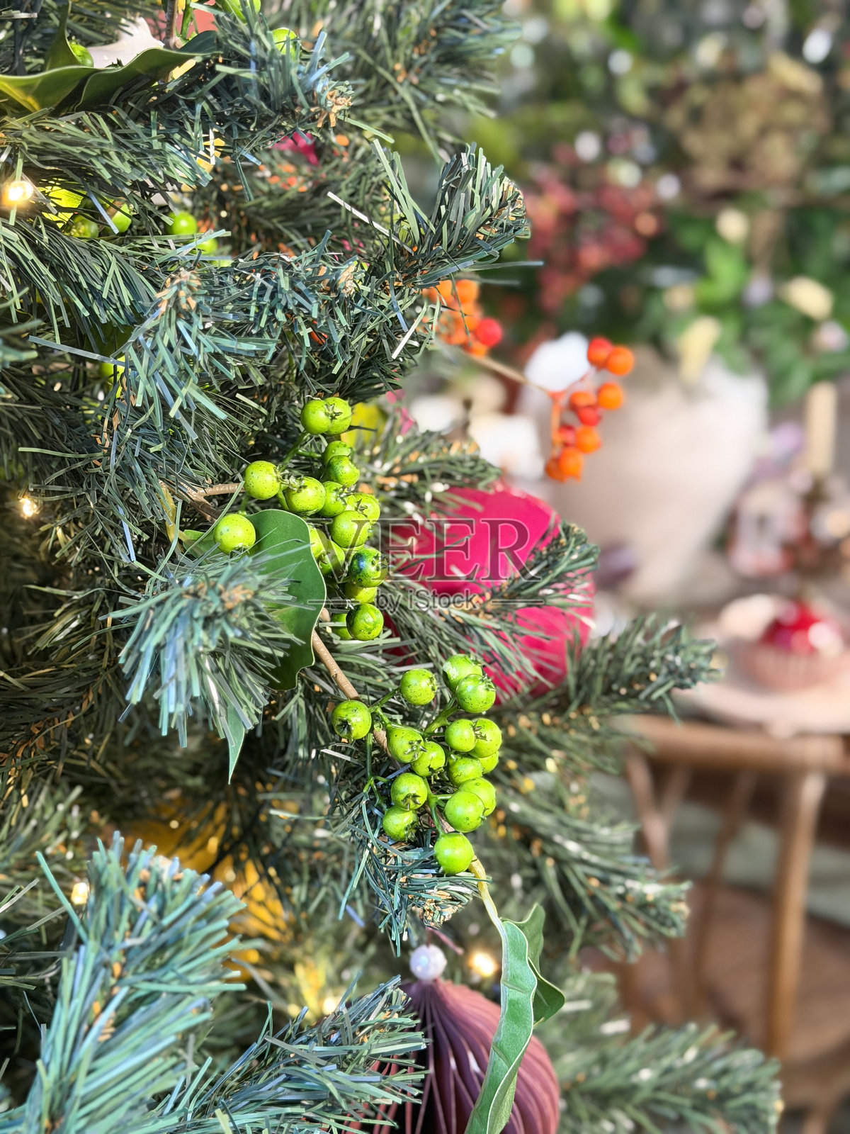 装饰着彩灯和饰品的圣诞树，旁边是节日晚餐餐桌和椅子照片摄影图片