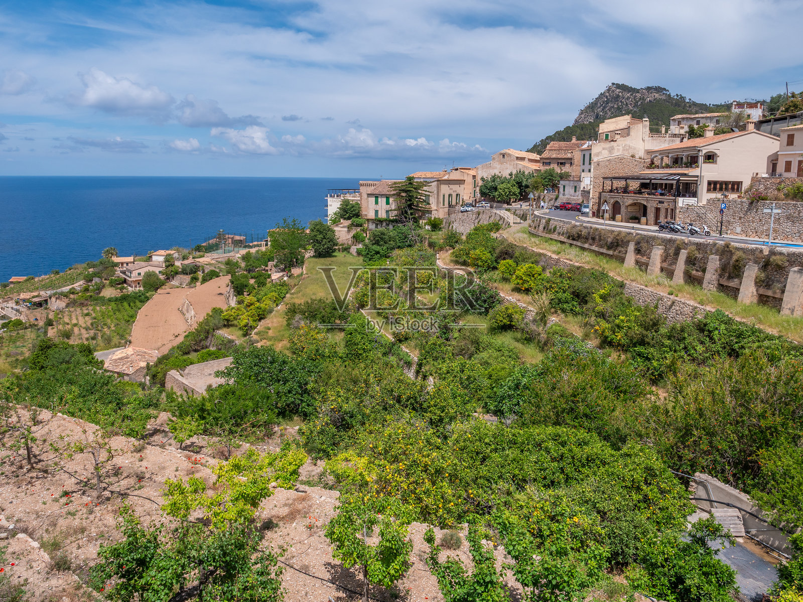 巴尼亚尔布法尔，马略卡岛。风景如画的海滨小镇坐落在山坡上，背景是郁郁葱葱的绿植和地中海。照片摄影图片