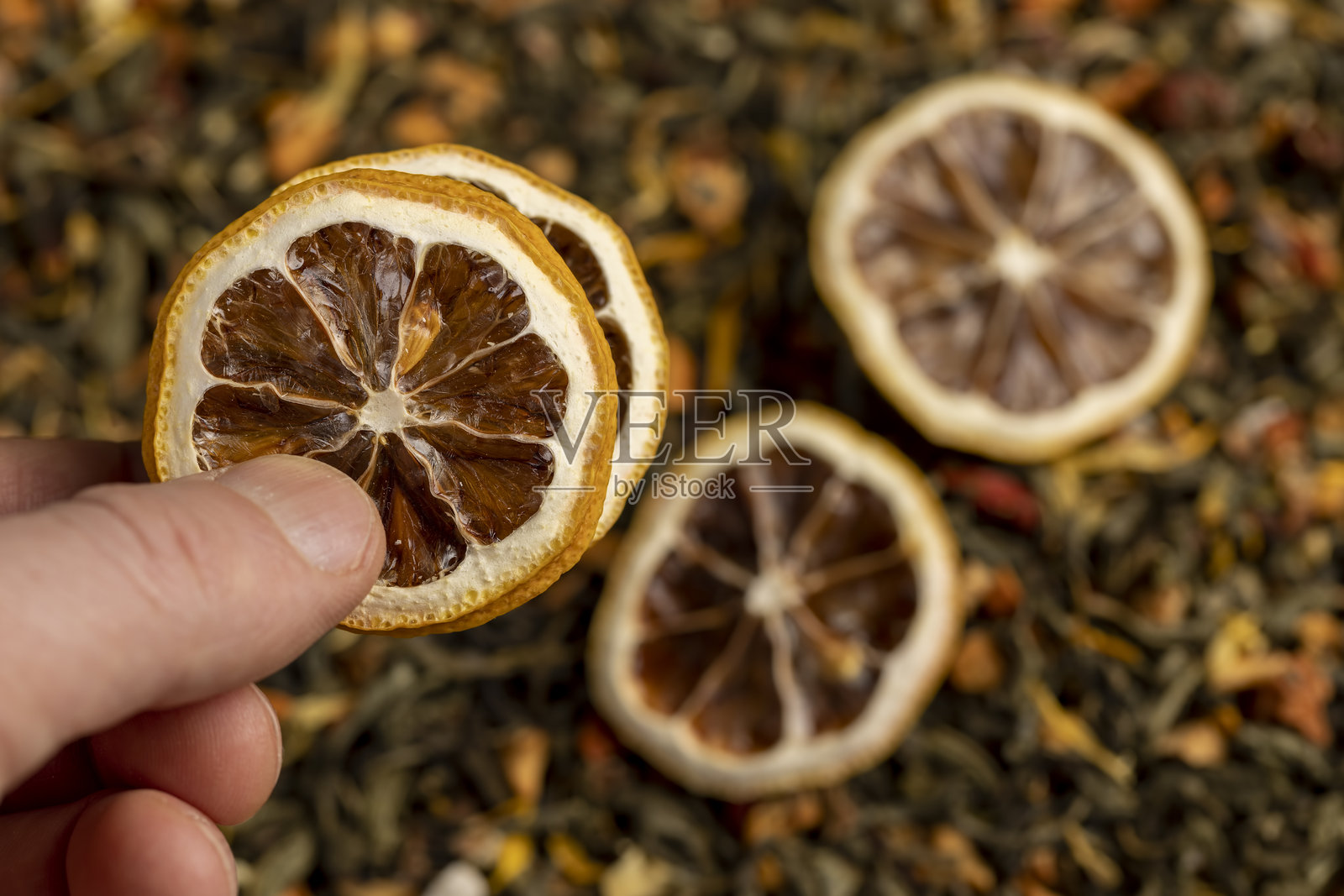添加了风味、水果块和切干黄柠檬的绿茶，明亮的大片干柠檬片和带有水果块的绿茶照片摄影图片