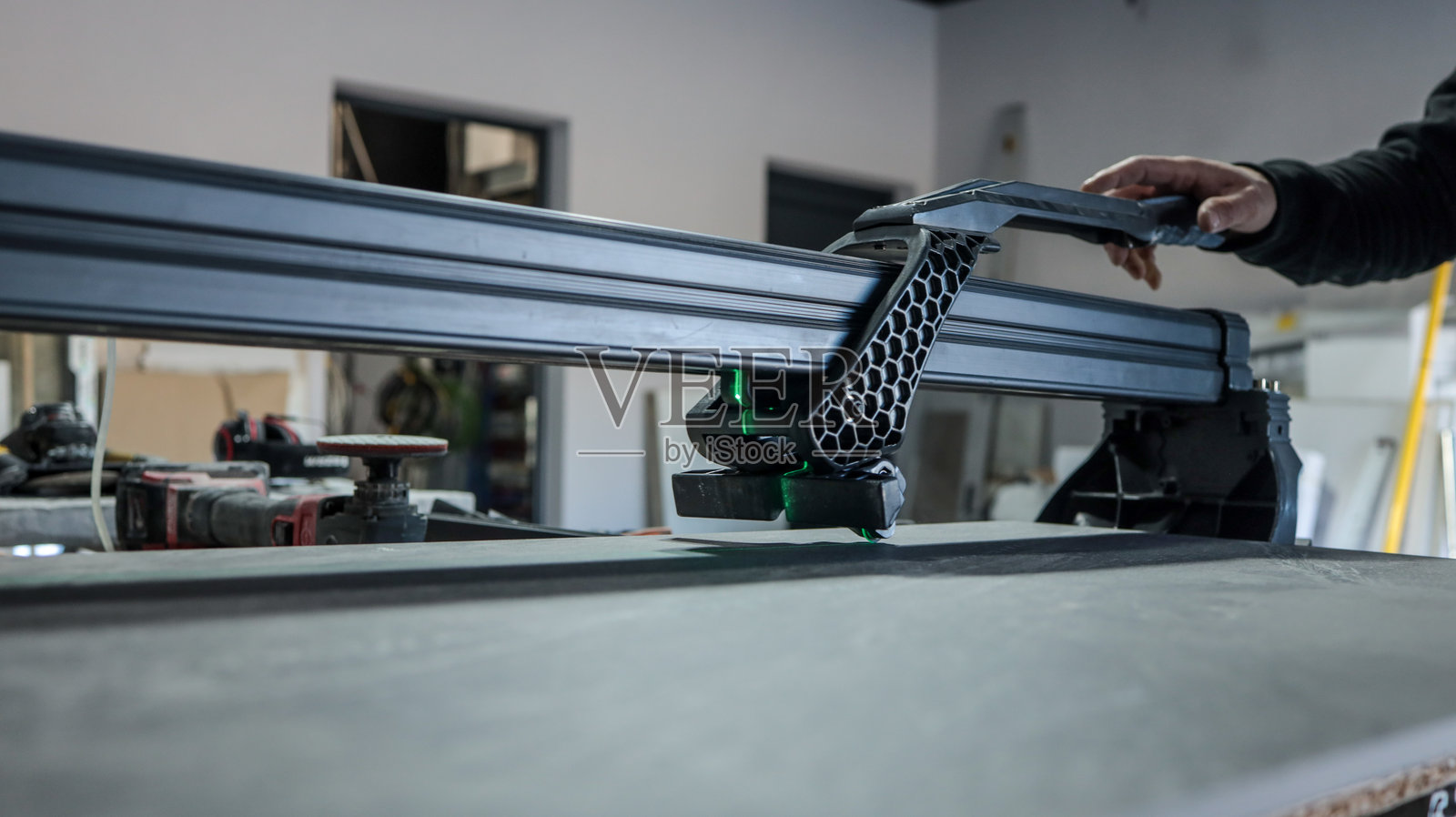 一名男子在车间里使用瓷砖切割机切割大块瓷砖照片摄影图片