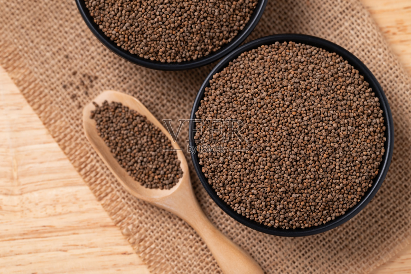 碗里放着紫苏籽，棕色背景上的勺子照片摄影图片