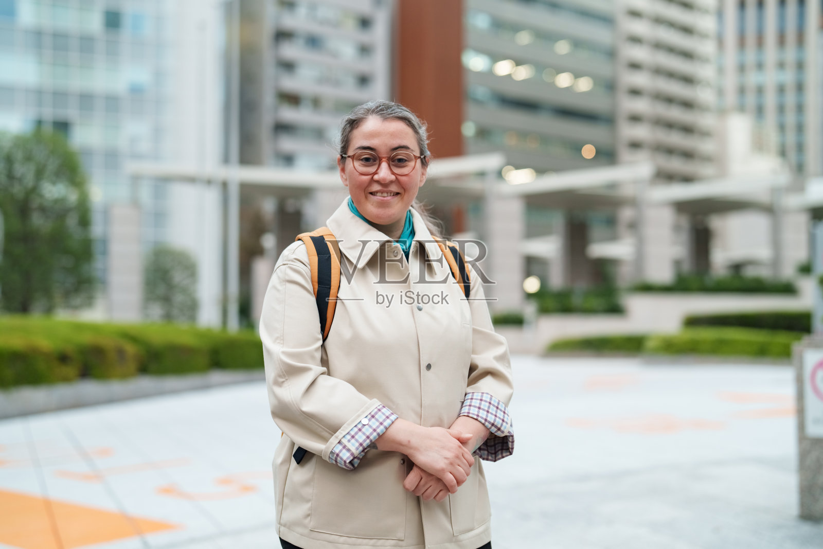 自信的女性看向镜头，背景是现代都市照片摄影图片