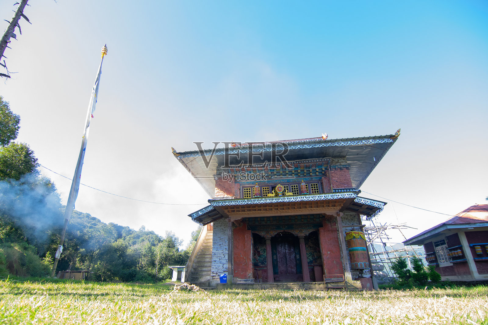 林钦彭寺,正面视图,背景为晴朗无云的蓝天和喜马拉雅山脉。照片摄影图片