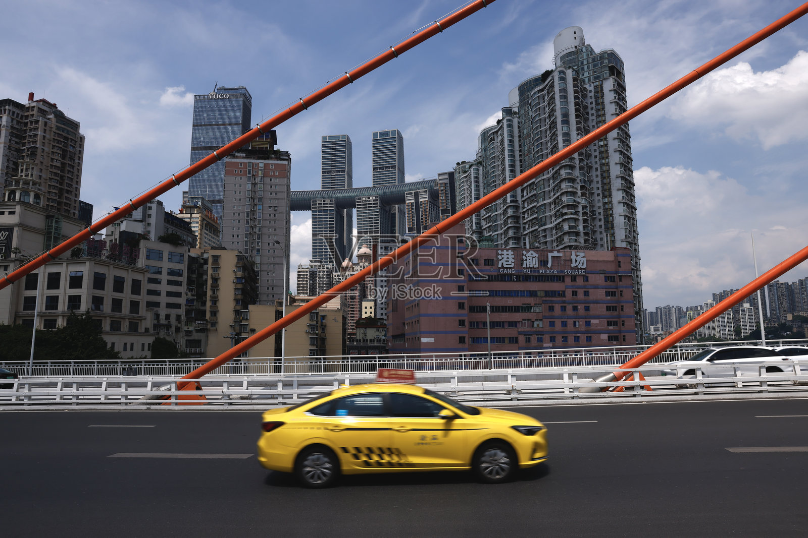 中国重庆，黄色出租车行驶在现代天际线下的城市桥梁上。照片摄影图片