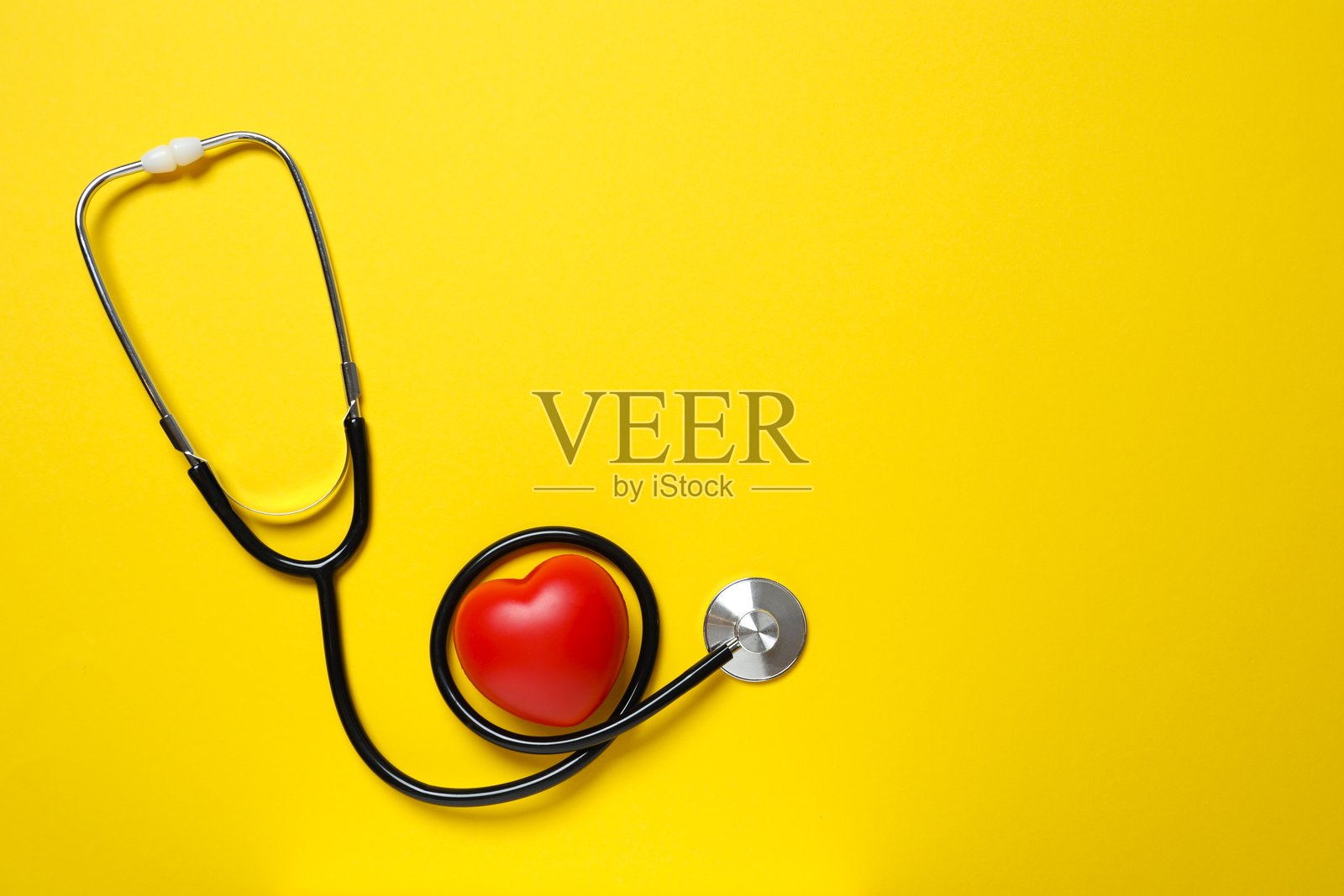 俯视视角，黄底红心听诊器照片摄影图片