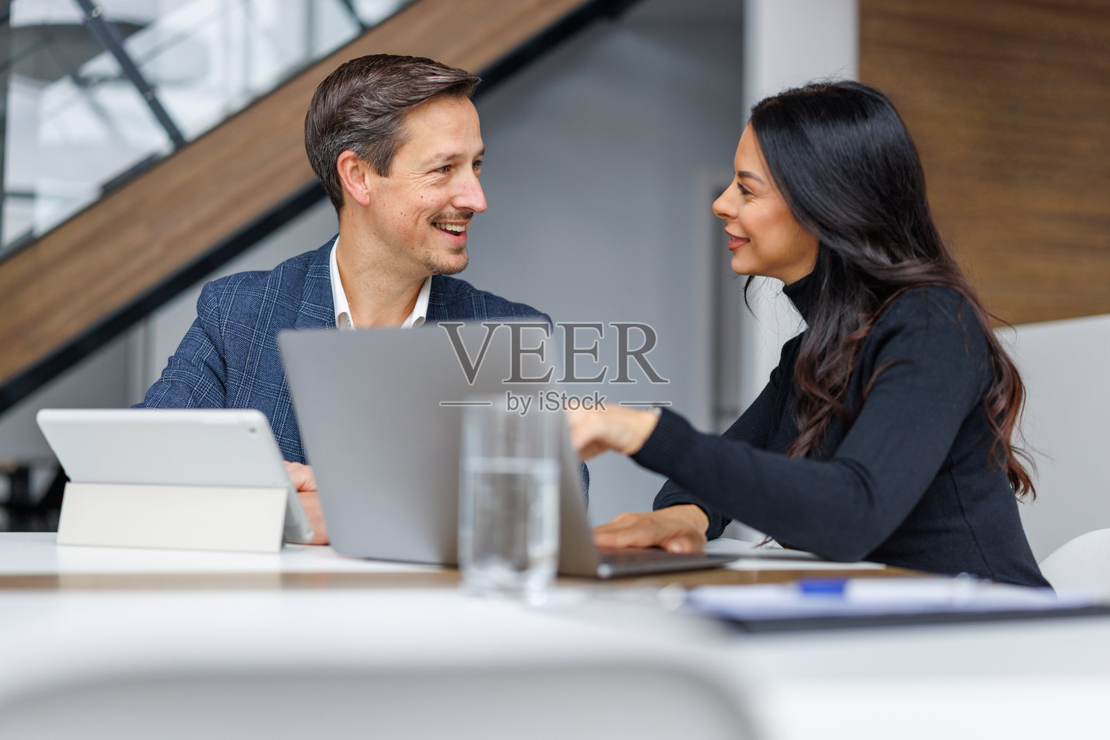 商务同事在现代办公室协作使用笔记本电脑照片摄影图片