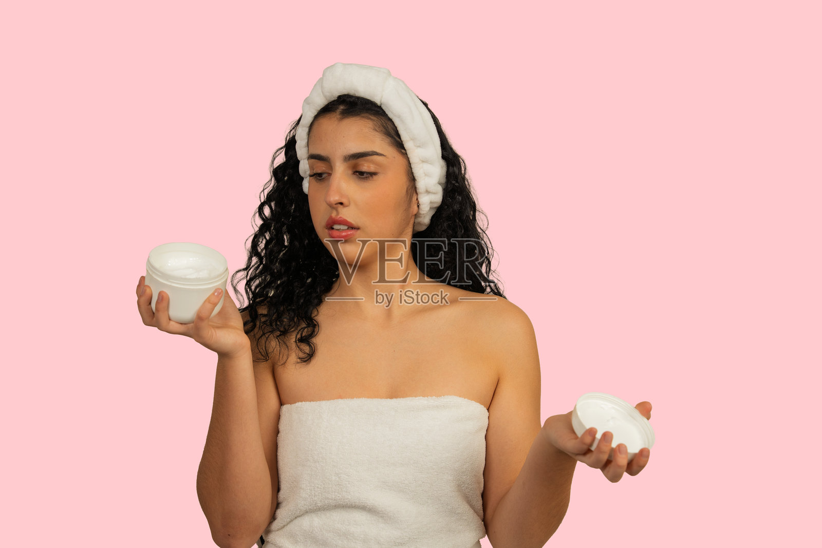 年轻女子在选择美容霜容器照片摄影图片