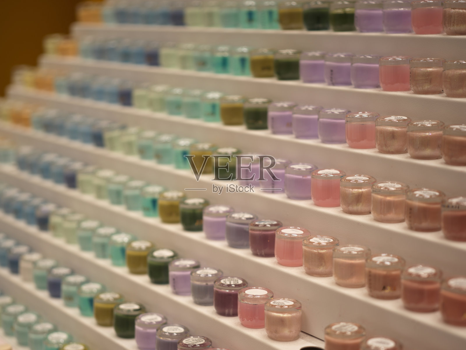 美容店分层货架上摆放着色彩缤纷的指甲油瓶照片摄影图片