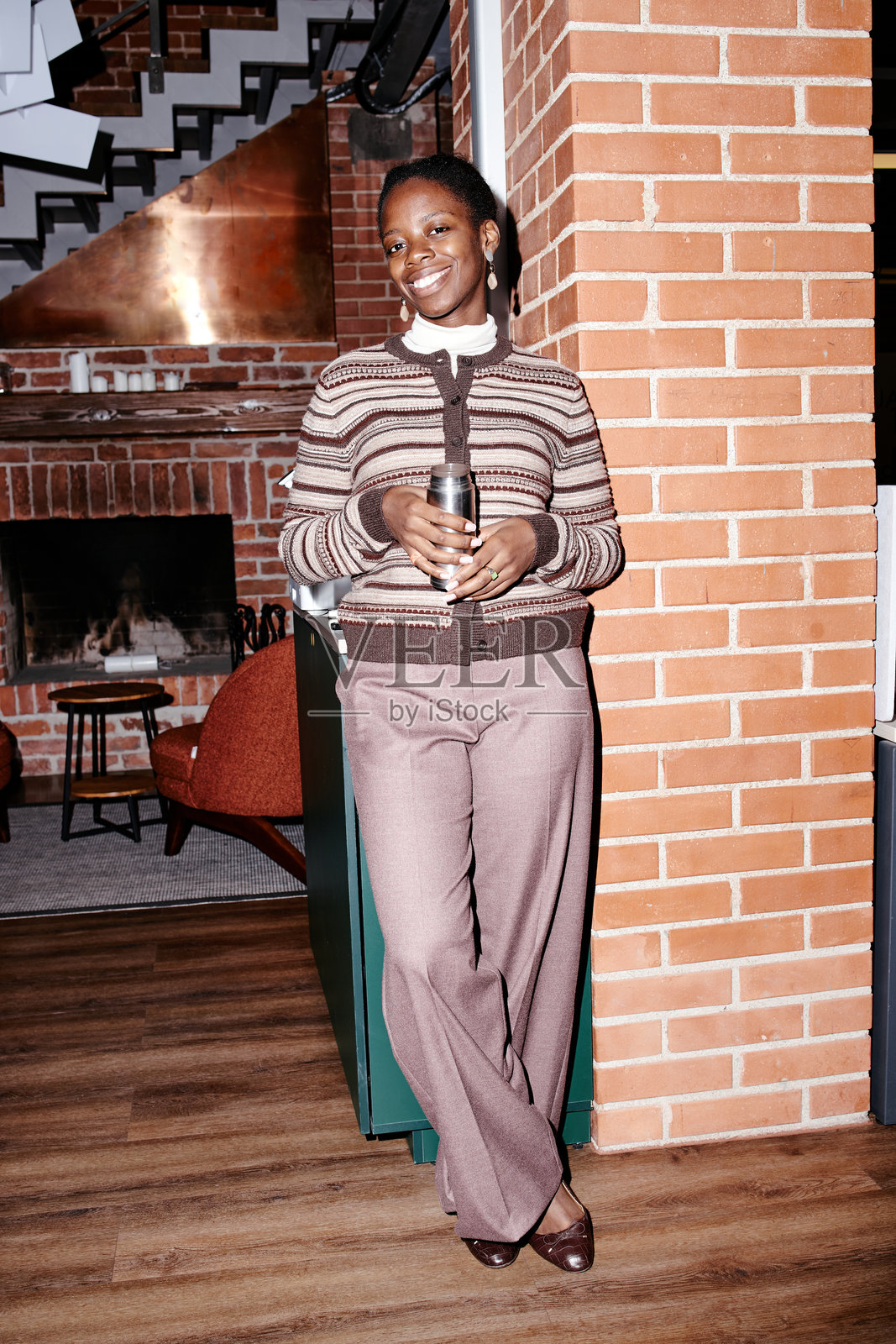 年轻黑人女性肖像，在办公室里微笑着拿着咖啡照片摄影图片